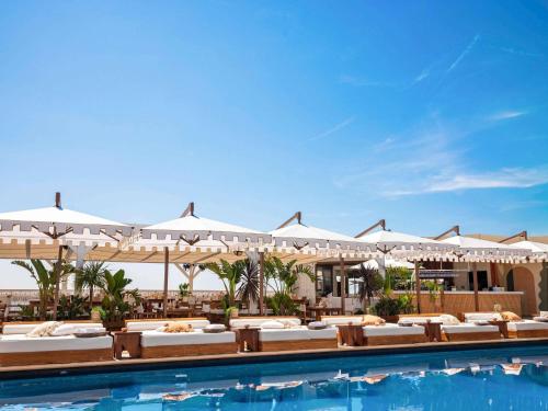 a pool at a resort with tables and umbrellas at Fairmont Monte Carlo in Monte Carlo