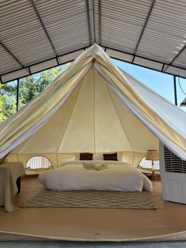 a large tent with a bed in it at Glampin By Tharu Garden in Sauraha