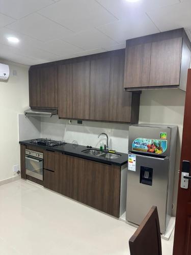 een keuken met houten kasten en een roestvrijstalen koelkast bij Edificio El Molino in Tarija