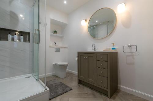 a bathroom with a shower and a sink and a mirror at Stonehaven ground floor home with a spectacular harbour view. in Stonehaven