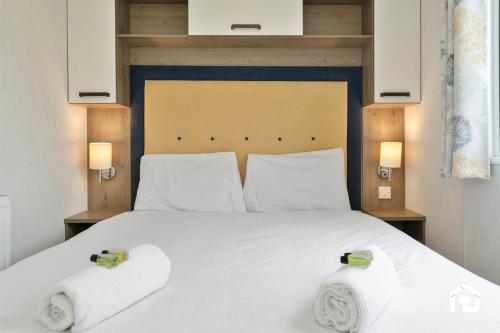 a bedroom with a large white bed with two towels at Vacant Nests Seton Sands Kings Barns Starlink in Longniddry