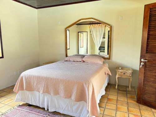 a bedroom with a bed with a large mirror at Oceana Suites Vila da Mata in Pipa