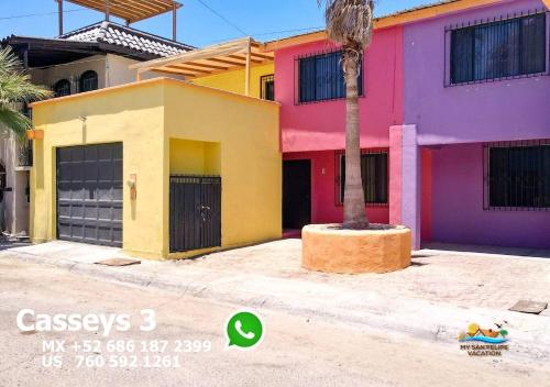 a colorful house with a palm tree in front of it at Condo 3, Easy Walk to San Felipe Malecon in San Felipe
