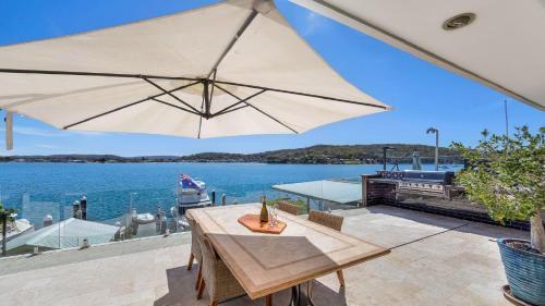 una gran sombrilla en un patio con vistas al agua en 'Waterfront Studio' by HolidayCo, en Blackwall