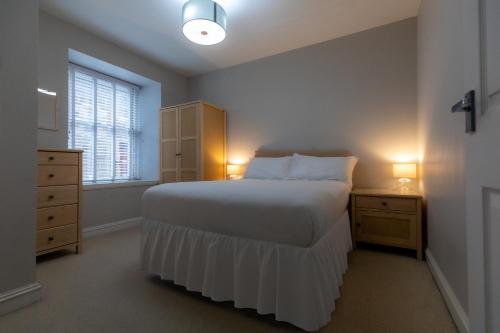 a bedroom with a bed and a dresser and a window at Stonehaven ground floor home with a spectacular harbour view. in Stonehaven