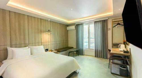 a hotel room with a large bed and a television at browndot 서천 