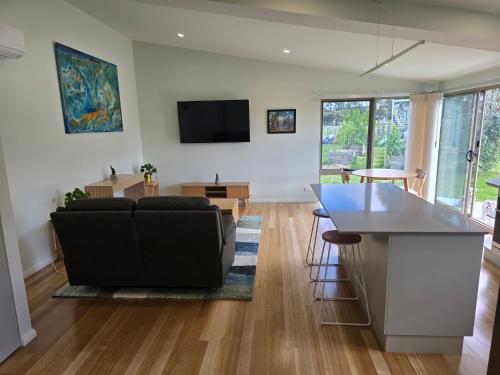 a living room with a couch and a table at Urban Retreat near Hobart & Airport, Port Arthur in Penna