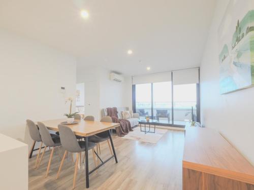a dining room and living room with a table and chairs at 3BR2BA apt in FootscaryPoolCAR PARKwifi in Melbourne