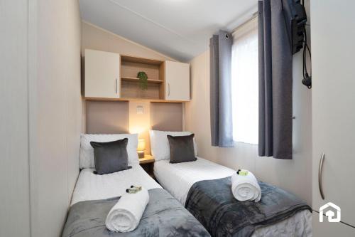 two twin beds in a room with a window at Vacant Nests The Archerfield Seton Sands in Longniddry