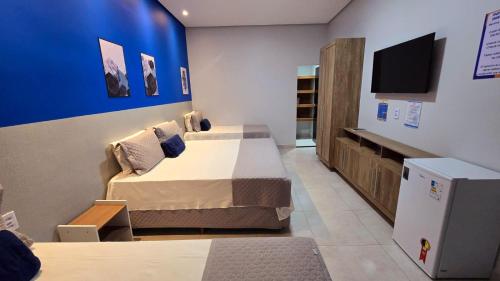 Conceição do AraguaiaにあるAraguaia Plaza Hotelのベッド2台と壁掛けテレビが備わる客室です。