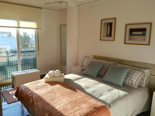a bedroom with a large bed and a large window at Encalma Vacacional El Ático in Puerto de Sagunto