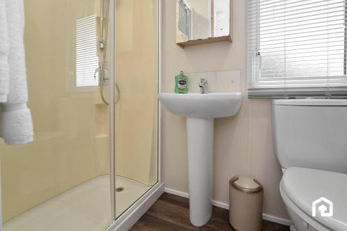a bathroom with a shower and a sink and a toilet at Vacant Nests The Archerfield Seton Sands in Longniddry