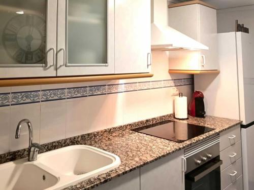 a kitchen with a sink and a counter top at Encalma Vacacional El Ático in Puerto de Sagunto