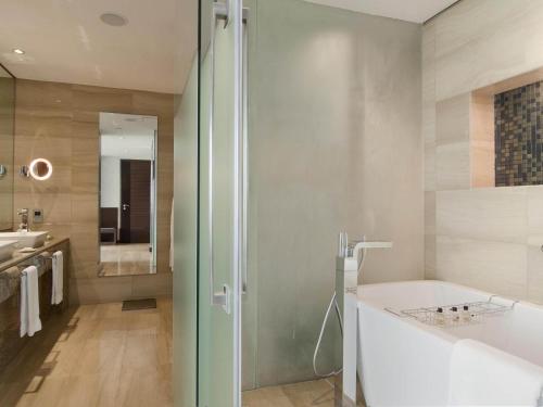 a bathroom with a tub and a sink and a shower at Fairmont Bab Al Bahr in Abu Dhabi