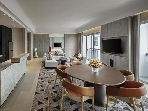 ein Wohnzimmer mit Sofa, Tisch und Stühlen in der Unterkunft Fairmont Singapore in Singapur
