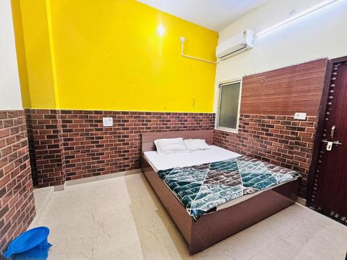 a small room with a bed in a brick wall at Bala ji guest house in Vrindāvan