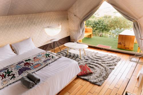 a bedroom in a tent with a bed and a rug at Danny Glamping Farm in Bao Loc