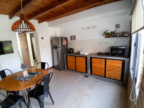 a kitchen with a wooden table and a dining room at Malvón in Cafayate