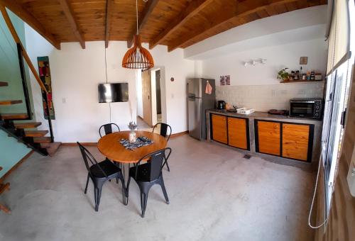 a kitchen and dining room with a wooden table and chairs at Malvón in Cafayate