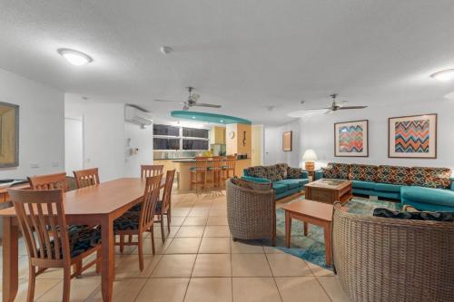 a dining room and living room with a table and chairs at Brisbane Road Apartments Mooloolaba in Mooloolaba