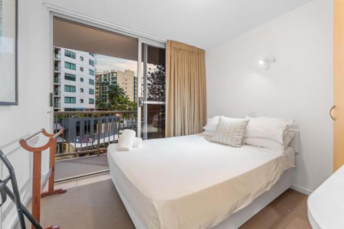 a bedroom with a bed and a large window at Brisbane Road Apartments Mooloolaba in Mooloolaba
