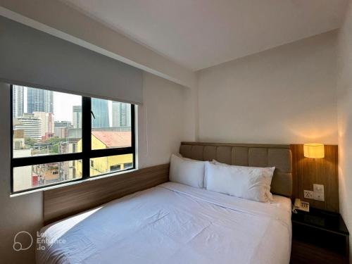a bedroom with a bed with a large window at D Loft Hotel in Kuala Lumpur
