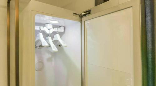 a glass door with white shoes hanging on a wall at browndot 서천 