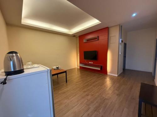 an empty room with a kitchen with red cabinets at CheckInn Kan Resort Kanchanaburi in Kanchanaburi City