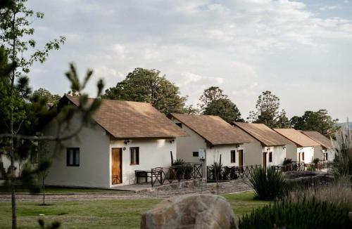 a row of white cottages in a row at Hotel Puerta de Piedra in Tapalpa