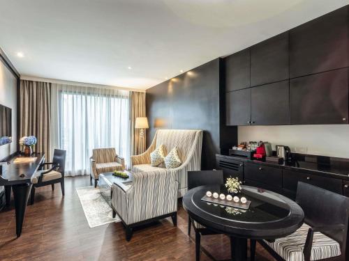 a living room with a couch and a table at Mövenpick Hotel Sukhumvit 15 Bangkok in Bangkok