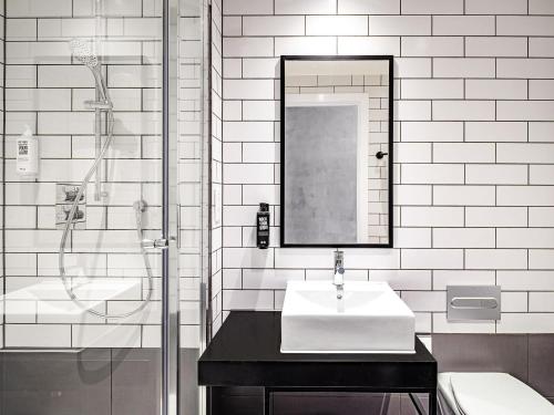 a black and white bathroom with a sink and a shower at ibis Bridgwater, M5 Jct23 in Bridgwater