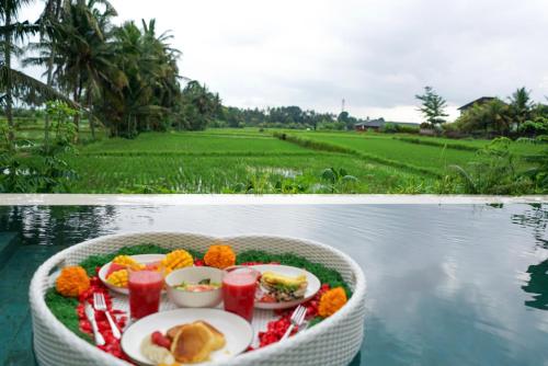ein mit Speisen und Getränken gefüllter Korb auf einem Gewässer in der Unterkunft Ubud Dzen Villa 9 in Ubud