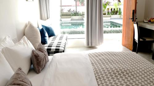 a bedroom with a bed and a view of a pool at Serenity Angkor in Phum Pobos