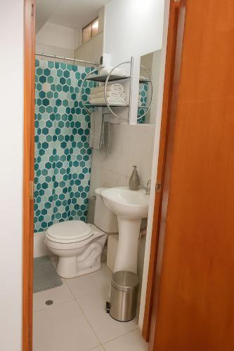 a small bathroom with a toilet and a sink at Suspiros de arica in Arica