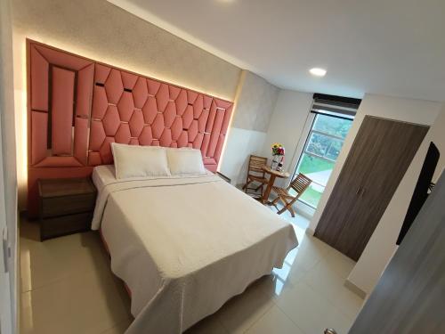 a bedroom with a large bed with a red headboard at New Hotel Vip in Bogotá