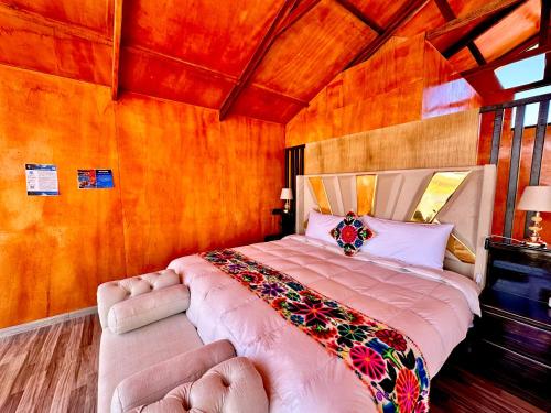 a bedroom with a large bed in a room at Titicaca Samay Lodge Perú in Puno