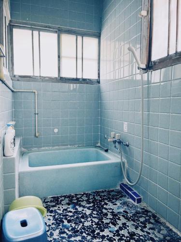 a bathroom with a blue tub and a toilet at 直島古民家一棟貸し笑くんNaoshima 'Shoukun' Entire house in Naoshima