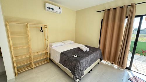 a small bedroom with a bed and a window at pipa paradise lofts in Tibau do Sul