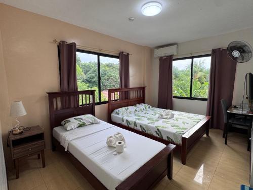 two beds in a room with a window at V.P. GO INN in Solangon