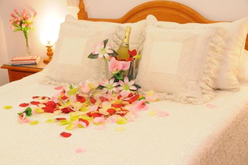 a bed with flower petals on it at Amplio Apartamento in Vecindario