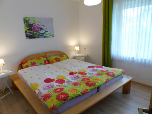 Un dormitorio con una cama con una manta de flores. en Ferienwohnung Lerchenweg en Möhnesee