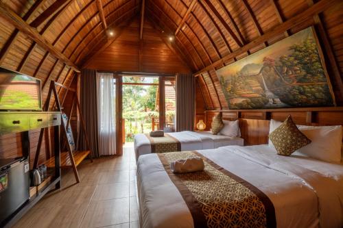 sypialnia z dwoma łóżkami i telewizorem w pokoju w obiekcie Puri Kurnia Ayu w mieście Ubud