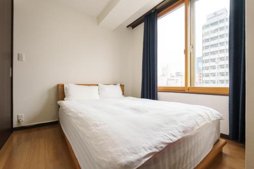 Postel nebo postele na pokoji v ubytování Nihonbashi Minshuku 智の居