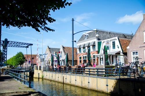 a group of people standing on a bridge over a canal at HCR Teernstra in Balk