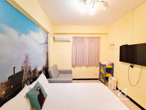 a room with a bed and a flat screen tv at 芳心蘭厝民宿 in Wujie