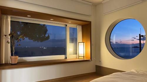 a bedroom with a large window with a potted plant at YeoulHyang, and Dam in Yŏng-do