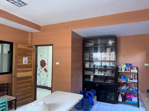 a kitchen with orange walls and a shelf with products at V.P. GO INN in Solangon