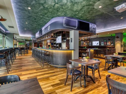 a restaurant with tables and chairs and a bar at ibis Styles Hamburg Barmbek in Hamburg