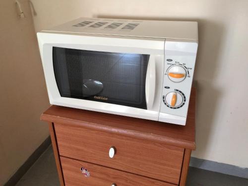 a microwave oven sitting on top of a wooden dresser at 2 bedroom apartment in Atlit, Haifa district in Atlit