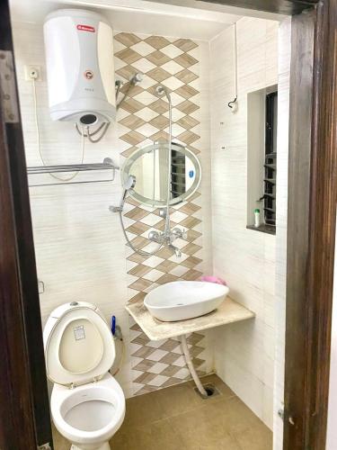a bathroom with a toilet and a sink at Sun & Sand Candolim Goa in Candolim